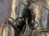 a statue of two people sitting on a couch with a laptop