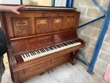 un homme debout à côté d'un piano dans une pièce