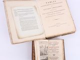 un livre ouvert posé sur une table à côté d'un livre