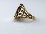 yellow gold ring with a diamond cut out of it on a white surface