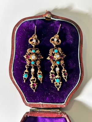 an image of a pair of earrings sitting in a purple case