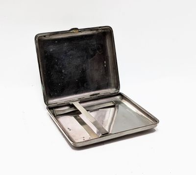 une petite boîte en métal contenant une paire de ciseaux