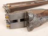 pair of old guns with wooden grips on a white surface