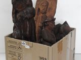 deux statues en bois représentant des hommes assis dans une boîte