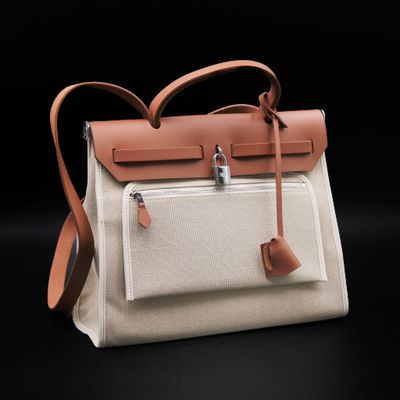 a close up of a white and tan bag with a brown handle