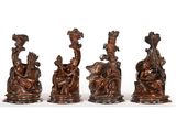 trois figurines en bronze représentant des personnes assises sur un banc