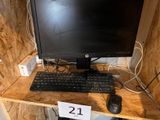 a computer monitor and keyboard on a desk with a price tag