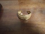un bracelet en or posé sur une table en bois