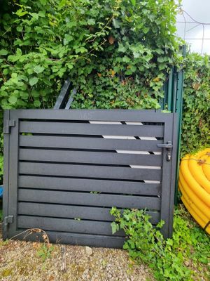 un tuyau jaune posé près d'une clôture et un tuyau jaune