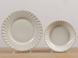two white plates with gold rims on a wooden table