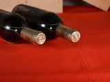 two bottles of wine sitting on a red table cloth
