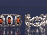 deux bagues en argent ornées de pierres rouges sur un fond bleu