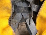 a close up of a yellow baseball glove with a tag on it