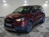 L'Opel rouge est garée dans une grande pièce au sol carrelé.