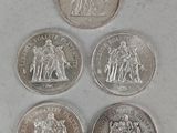 four different types of silver coins on a white surface