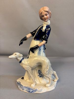 une figurine représentant une femme et un chien posée sur une table