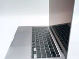 a silver laptop with a black keyboard on a white surface