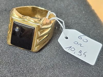 l'image d'une bague en or ornée d'une pierre noire