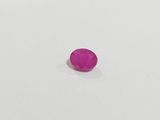 a pink oval stone on a white surface