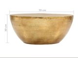 the large gold bowl is sitting on a white surface