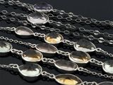 un gros plan sur un ensemble de colliers posés sur une surface noire