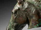 bronze head of a horse on a black background