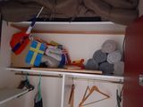 a closet with clothes and clothes hanging on the shelves