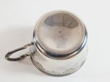 a silver cup with a handle on a white surface
