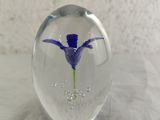 a glass ball with a purple flower inside of it