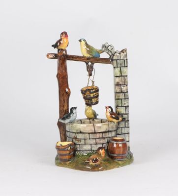 a figurine of a well with birds on it