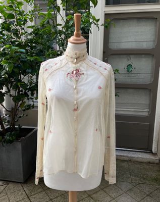 white shirt with pink flowers on it on a mannequin stand