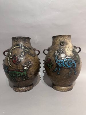two vases with designs on them sitting on a white surface