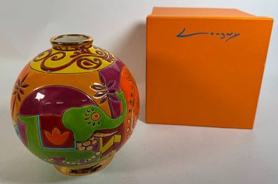 an image of a colorful vase sitting next to an orange box