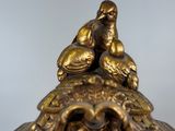 a gold clock with a bird on top of it