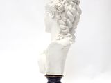 white marble bust of a woman with curly hair on a black base