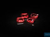trois cubes en verre rouge posés sur une surface noire