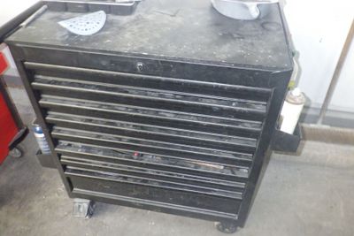une armoire à outils noire sur laquelle est posée une paire de chaussures