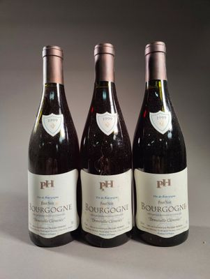 trois bouteilles de vin rouge sont alignées sur une table