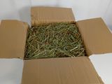 une boîte en carton remplie de foin posée sur une surface blanche
