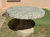 une table en pierre posée au milieu d'une cour