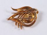 a gold brooch with a leaf shaped design on it