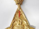 an image of a gold medal with a red cross on it