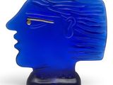 a blue glass sculpture of a woman ' s face on a stand