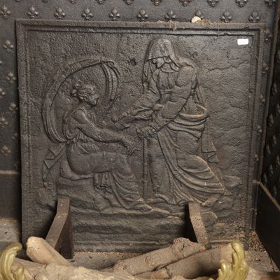 a statue of a man and a woman sitting on a bench next to a pile of logs