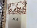 a picture of a menu in a binder on a table