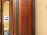 a tall wooden cabinet with a mirror on top of it