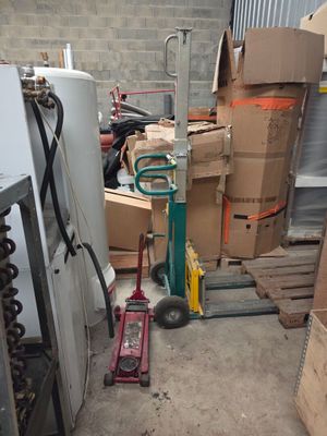 une pile de cartons et un diable dans un entrepôt