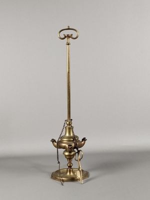une lampe à huile ancienne en laiton, dotée d'un abat-jour en verre et posée sur un pied