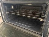an open oven with the door open and a rack in the oven