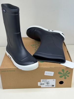 une paire de bottes de pluie noires posée sur un carton